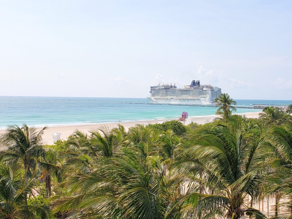 Cruceros navegando cerca de Government Cut vistos desde South Beach, con el océano y skyline de Miami al fondo.
